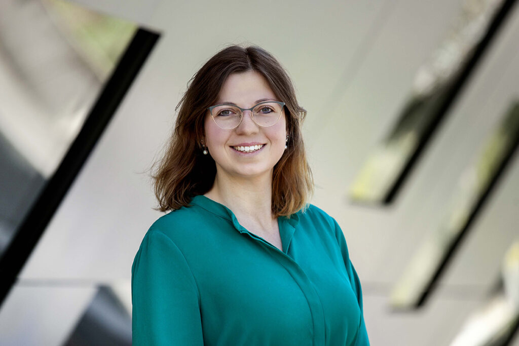 Frau im Business Look stet mit verschränkten armen an der Stadthalle Balingen. 