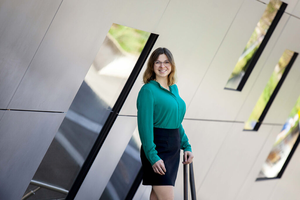 Frau im Business Look stet mit verschränkten armen an der Stadthalle Balingen. 