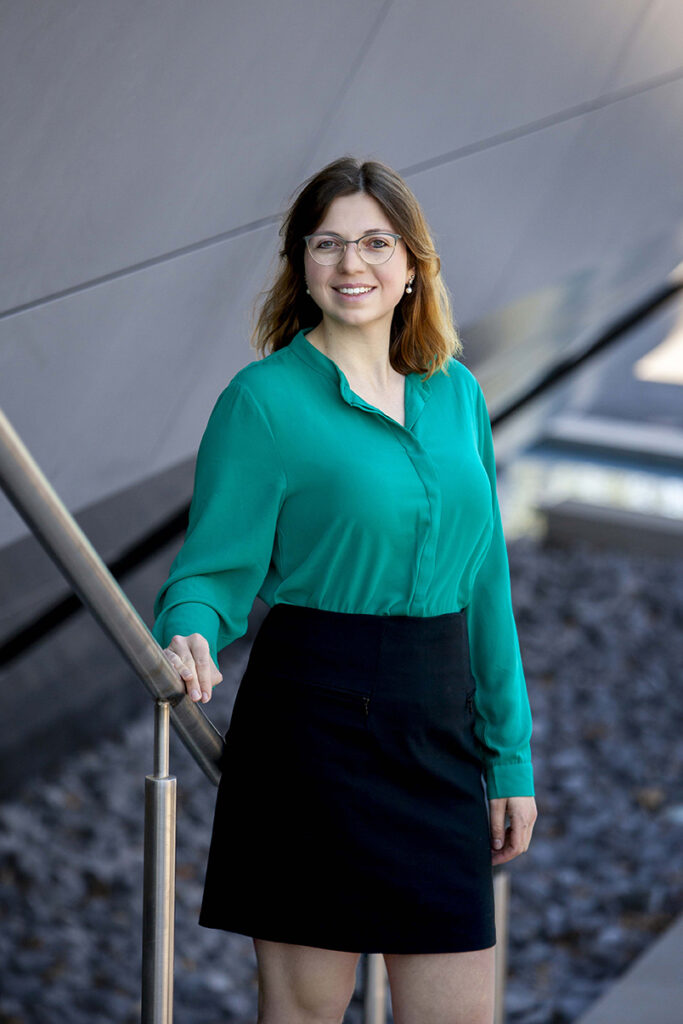 Frau im Business Look stet mit verschränkten armen an der Stadthalle Balingen. 