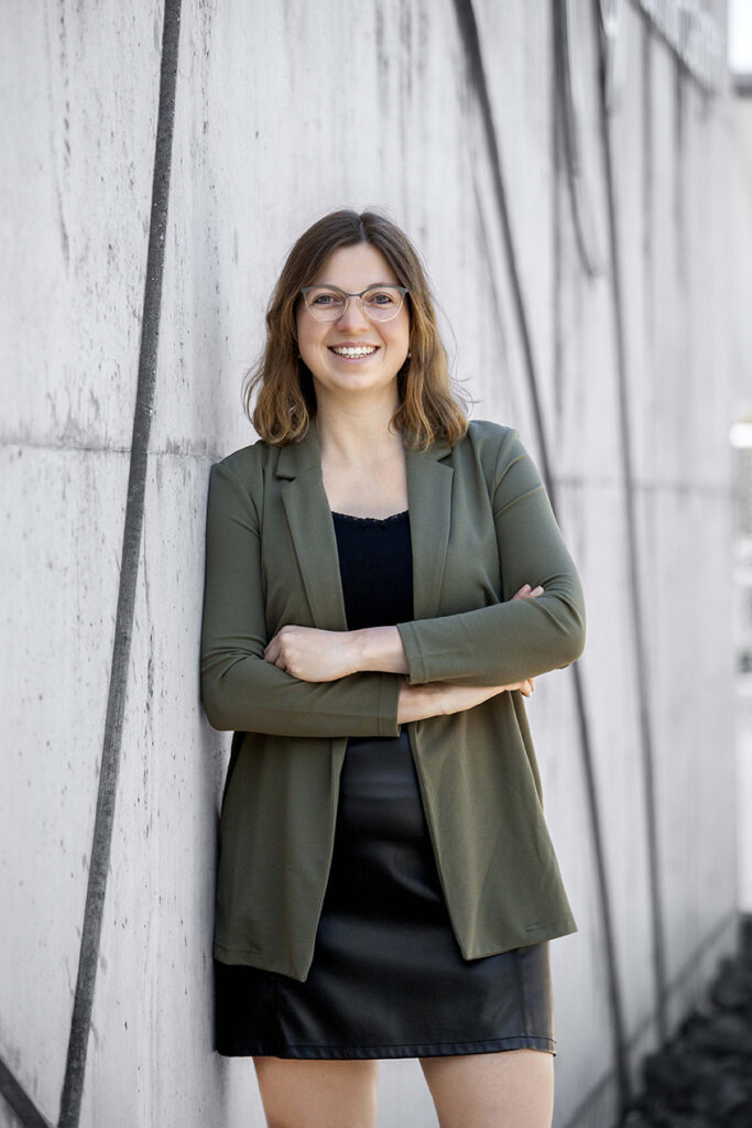 Frau im Business Look stet mit verschränkten armen an der Stadthalle Balingen. 