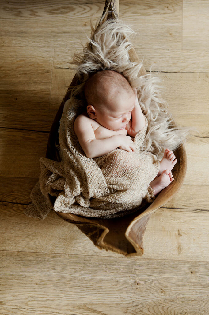 Baby liegt in einer Bananen schale und ist zum schlafen ganz klein zusammen gerollt,