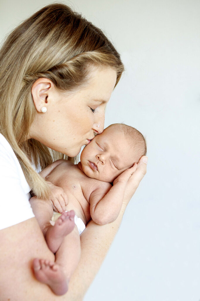 Mama Küsst Baby auf die Stirn, während dies schlief.