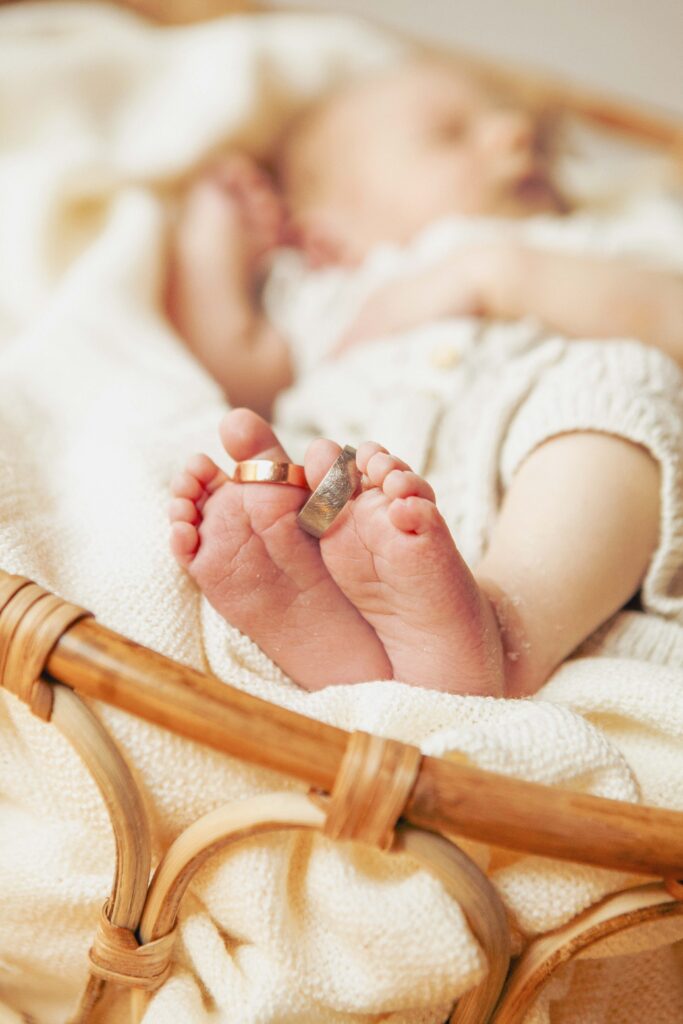 Babyfüßen an denen die Ehe ringe Hängen.