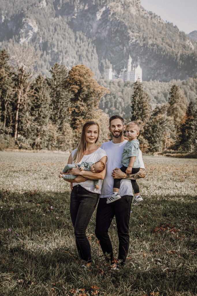 Frisch Gebackene Familie steht in der Natur in Füssen im Herbst.