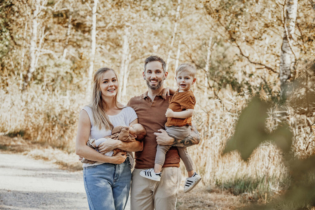 Frisch Gebackene Familie steht in der Natur in Füssen im Herbst.