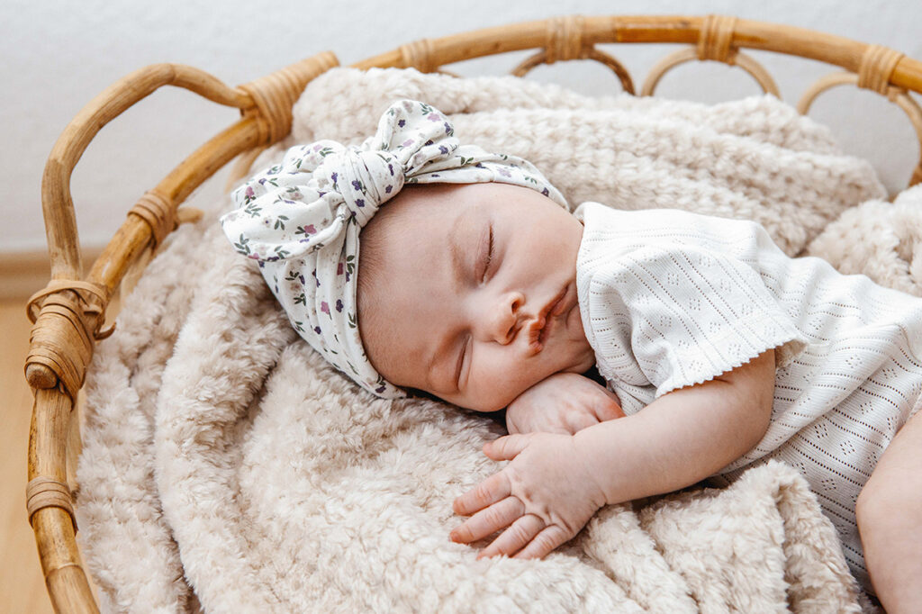 Baby liegt im Körbchen und schläft. 