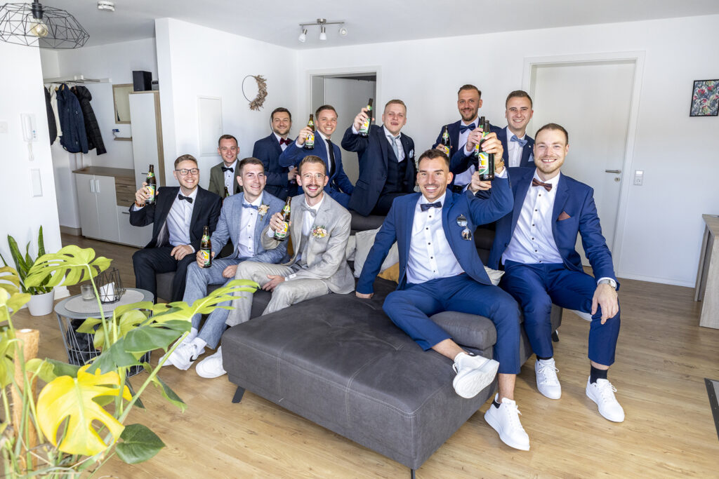 Jungs beim Richten vor der Trauung stoßen zusammen an und haben Spaß. Rangendingen.