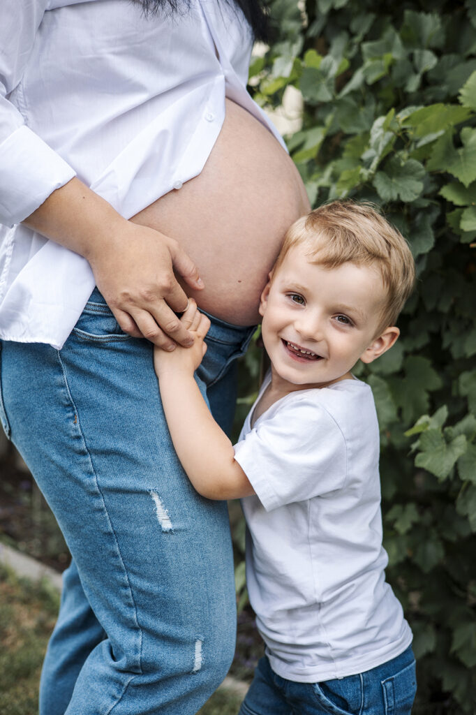 Großer stolzer Bruder Hält den nackten Babybauch. Empfingen.