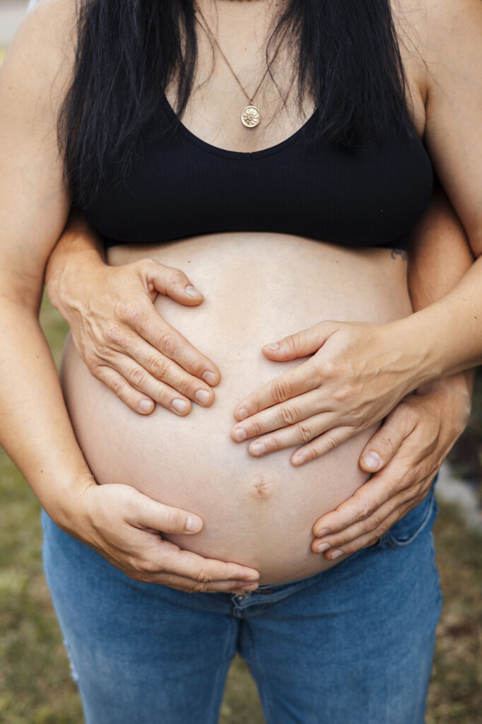 Babybauch mit Mama und Papa Händen auf nackten Bauch. Empfingen.
